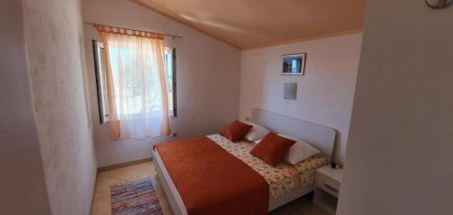 a bedroom with a bed with orange sheets and a window at Apartment in Sevid with Seaview, Terrace, WIFI (4746-1) in Sevid