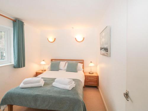 a bedroom with a bed with two towels on it at Bluebell Cottage in Paignton