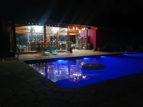 a swimming pool at night with blue lights at CHÁCARA Na Represa in Ibiúna