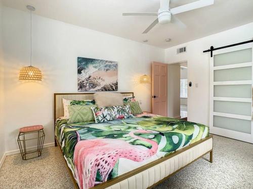 Dormitorio con cama con edredón de dragón en The Pink Flamingo Mid Century Heated Pool Paradise en Sarasota