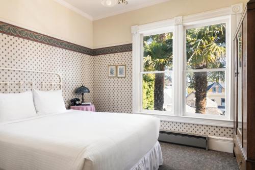 a bedroom with a white bed and a window at Centrella Hotel, a Kirkwood Collection Hotel in Pacific Grove