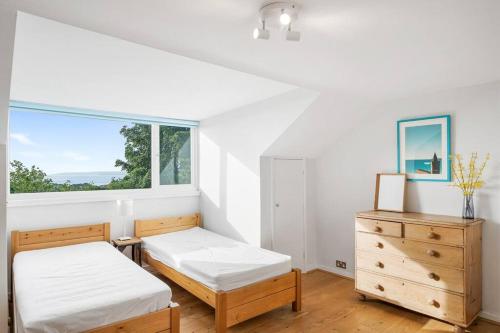 - une chambre avec 2 lits et une fenêtre dans l'établissement Manacles - Spacious flat near beach with sea views & parking, à Falmouth