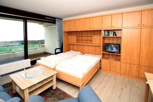 Un dormitorio con una cama y un televisor. en Gmelinstraße 5 c, Whg C9, By de Wyk, en Südstrand