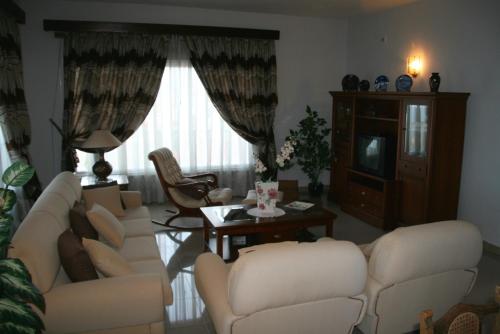 een woonkamer met witte banken en een televisie bij Vivienda Vacacional Paseo Mirabal in Icod de los Vinos