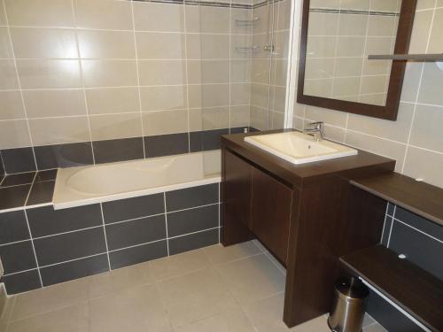 une salle de bain avec un lavabo et une baignoire dans l'établissement Appartement T2 avec Piscine, Proche Plage et Commerces à Sète - FR-1-472-113, à Sète