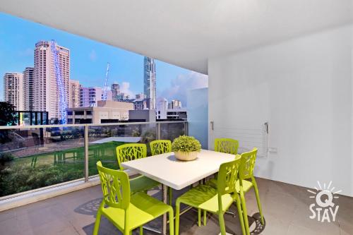 a dining room with a table and chairs and a large window at KIDS STAY FREE in Hinterland View 1 Bedroom SPA Apartment at Circle on Cavill - Q STAY in Gold Coast