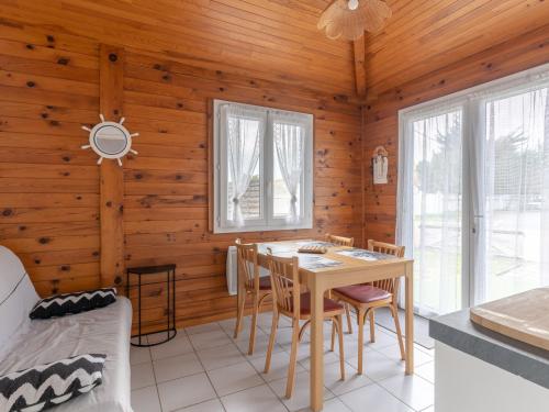 une salle à manger avec une table et des chaises dans une cabine dans l'établissement Maison T3 pour 4 personnes à 400m de la plage et du centre, avec terrasse et parking. - FR-1-521-210, à Biscarrosse