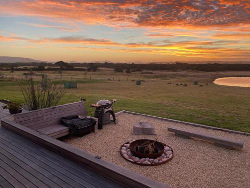 a backyard with a fire pit and a bench at Majuba Country Lodge in Kalgan