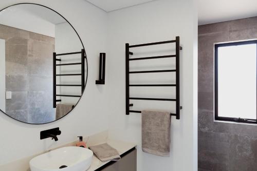 een badkamer met een wastafel en een spiegel bij Majuba Country Lodge in Kalgan