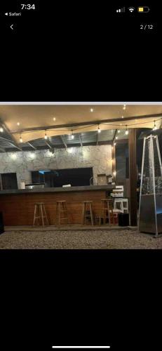 uma cozinha com um bar com bancos e um balcão em Chalet Castello em Ensenada