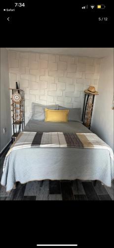 um quarto com uma cama grande e uma almofada amarela em Chalet Castello em Ensenada