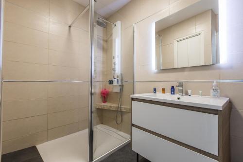 La salle de bains est pourvue d'une douche, d'un lavabo et d'un miroir. dans l'établissement Admire Panoramic Ocean Views Through Walls of Windows, à Cannes