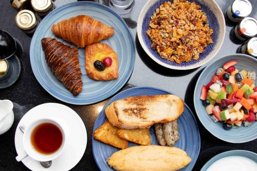 een tafel vol blauwe borden met eten en koffie bij InterContinental Phuket Resort by IHG in Kamala Beach