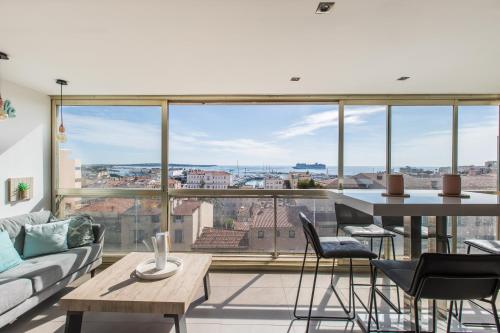Una sala de estar con una mesa y sillas y una gran ventana. en LB Vacation Rentals I Admire Panoramic Ocean Views Through Walls of Windows, en Cannes