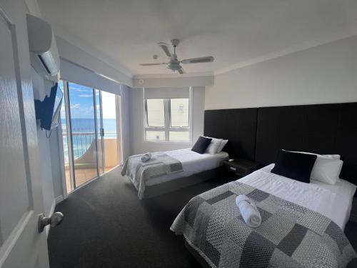 a hotel room with two beds and a balcony at Stunning 2 bedroom Ocean View Apartment in Gold Coast