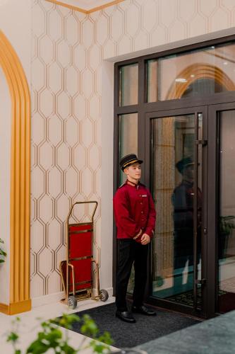a man is standing in front of a door at Boutique Hotel Silk Way in Türkistan