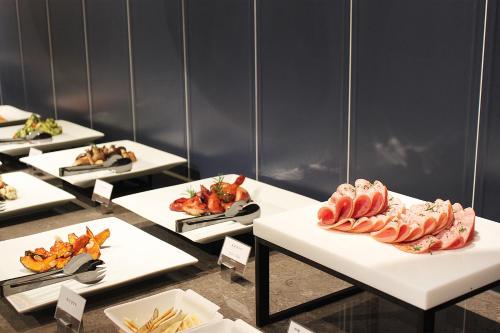 a row of tables with plates of food on them at JN PARK Hotel in Incheon