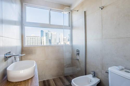 baño con aseo y lavabo y ventana en Apartment near to Recoleta & Puerto Madero en Buenos Aires