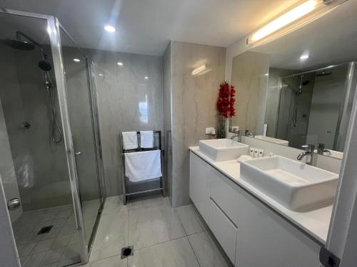 y baño con 2 lavabos y ducha. en Stunning 2 bedroom Ocean View Apartment en Gold Coast