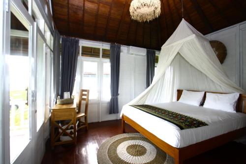a bedroom with a bed with a mosquito net at PASERANG PARIRI PARADISE in Labuberu