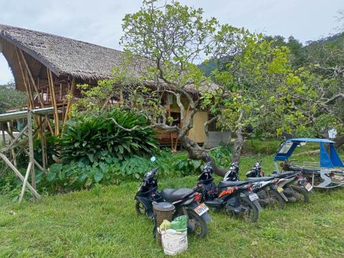 a group of motorcycles parked in front of a house at Surf and Skate Duli El Nido By Kiteclub Palawan in El Nido