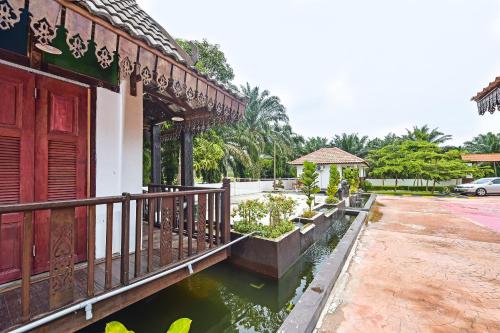 a building with a bridge over a body of water at Hotel O Jentayu Homestay Pontian in Pontian Kecil