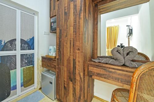Habitación con pared de madera y espejo. en OYO Home 90332 Jentayu Homestay Pontian en Pontian Kecil