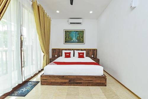 a bedroom with a large bed with red pillows at Hotel O Jentayu Homestay Pontian in Pontian Kecil