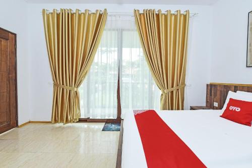 a bedroom with a bed and a large window at Hotel O Jentayu Homestay Pontian in Pontian Kecil