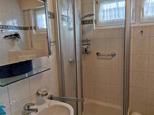 ein Bad mit einem Waschbecken und einer Dusche in der Unterkunft Haus Juist - Schillig in Wangerland