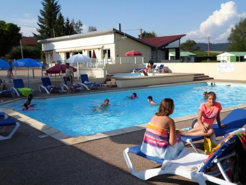 un groupe de personnes assises sur des chaises dans une piscine dans l'établissement Camping les Pinasses, à La Chapelle