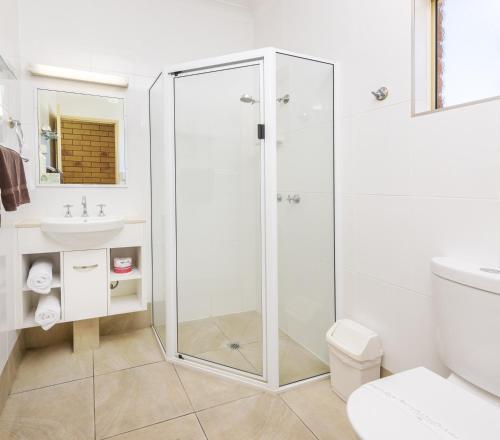 uma casa de banho com um chuveiro, um WC e um lavatório. em Roma Mid Town Motor Inn em Roma