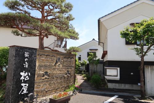 a gate in front of a building with a tree at Kuranoyado Matsuya in Fujikawaguchiko
