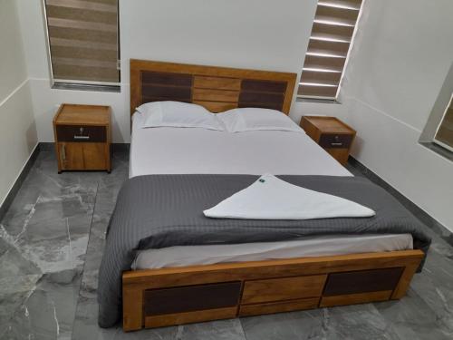 Milestone Inn في سلطان بتيري: غرفة نوم بسرير كبير مع مواقف ليلتين