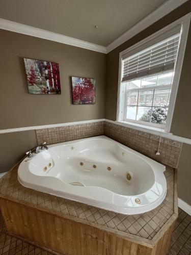 a large bath tub in a bathroom with a window at Mt Olympus Cabin, Cozy 1 bedroom cabin Great for couples in Estes Park