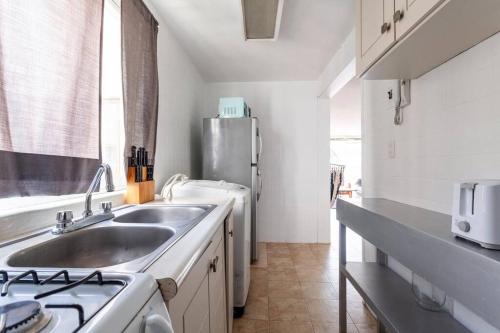 a kitchen with a sink and a stainless steel refrigerator at Condesa, Depto 2 recamaras. in Mexico City