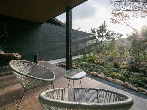 two chairs and a table on a patio with a view at Bettei Fujiya in Miyajima