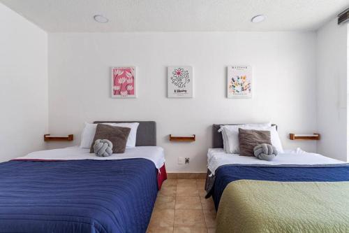 a bedroom with two beds with blue and white sheets at Condesa, Depto 2 recamaras. in Mexico City