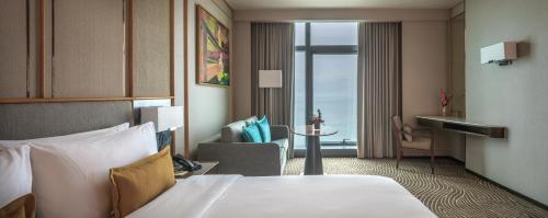 una camera d'albergo con letto e soggiorno di Fili Hotel at Nustar Cebu a Cebu City
