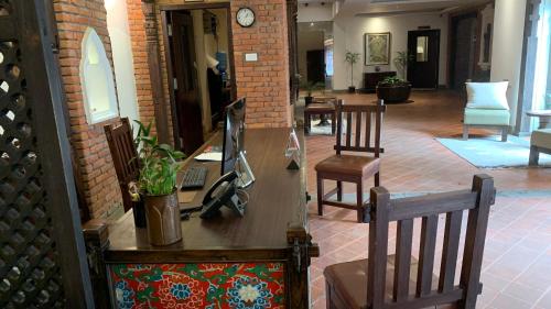 a lobby with chairs and a desk and a clock at Hotel Thamel House - 6 km from Boudhanath Stupa, Kathmandu in Kathmandu