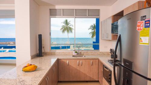 une cuisine avec une grande fenêtre donnant sur l'océan dans l'établissement Magico Apartamento Frente al Mar 3 Habitaciones PAZ224, à Coveñitas