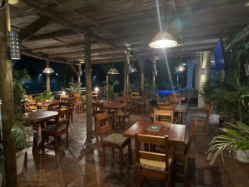 un restaurante con mesas de madera, sillas y luces en Le Gite du Bonheur Guest House & Car Rental en Tamarin