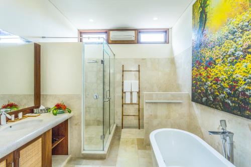 a bathroom with a shower and a sink and a tub at Pearl Sunset Resort in Gili Trawangan