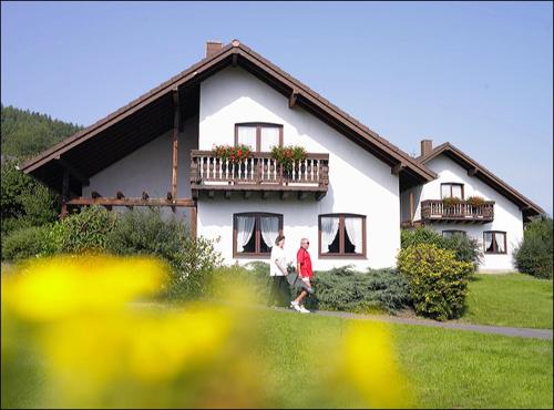 two people walking in front of a house at Ferienpark Rursee in Simmerath