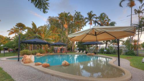 uma piscina com um guarda-chuva e pedras em BIG4 Lucinda Wanderers Holiday Park em Lucinda
