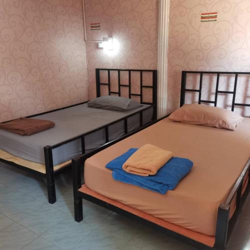 Dos camas en una habitación con toallas. en Haadrin Village near the pier, en Haad Rin