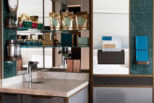 a kitchen with a counter and a shelf with boxes at Island Shangri-La, Hong Kong in Hong Kong