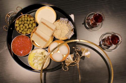 a plate of food with eggs cheese and other foods at RAWND Hotel Apartments in Dammam