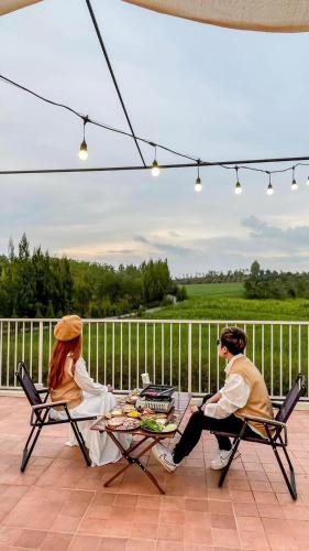 two people sitting at a table on a patio at SOL Glamping at Khao yai in Ban Nong Makha