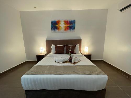 a bedroom with a large bed with two candles on it at DSH Hotel in Kuantan